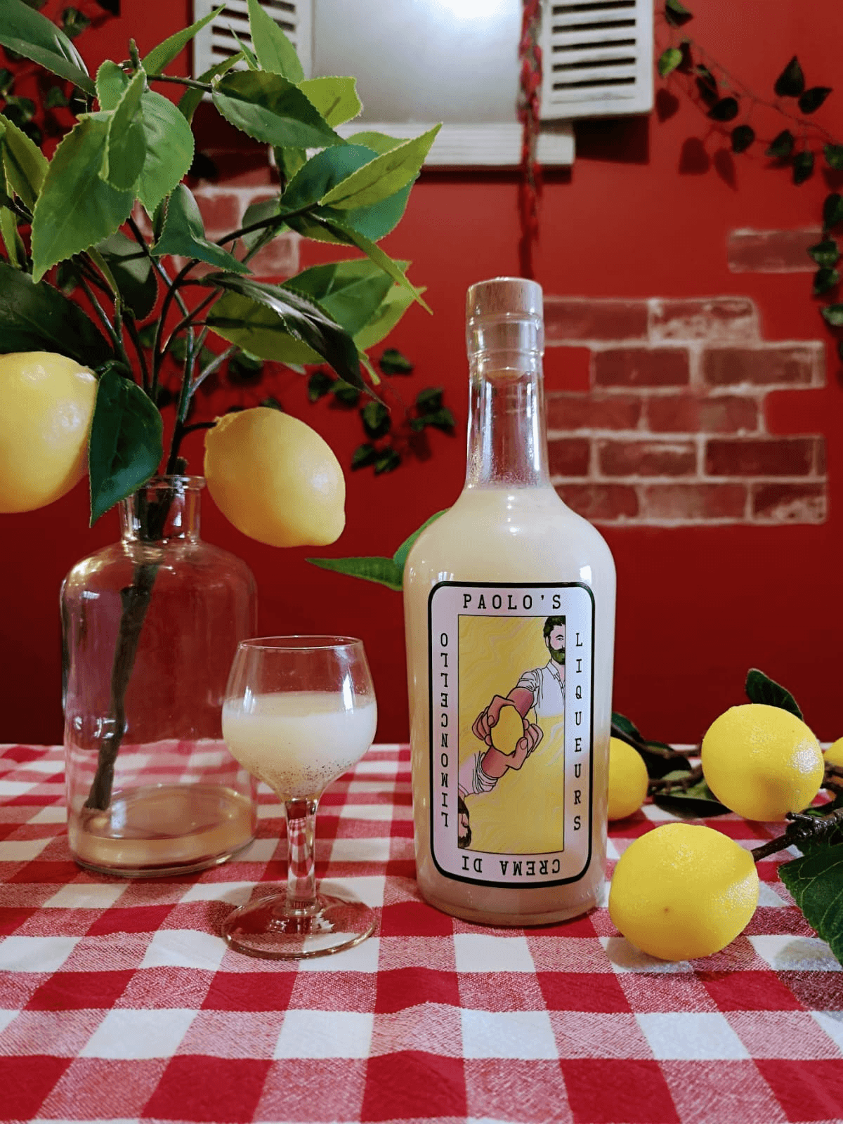 A picture of bottle of crema di limoncello on a chequered table cloth by Paolo's Liqueurs