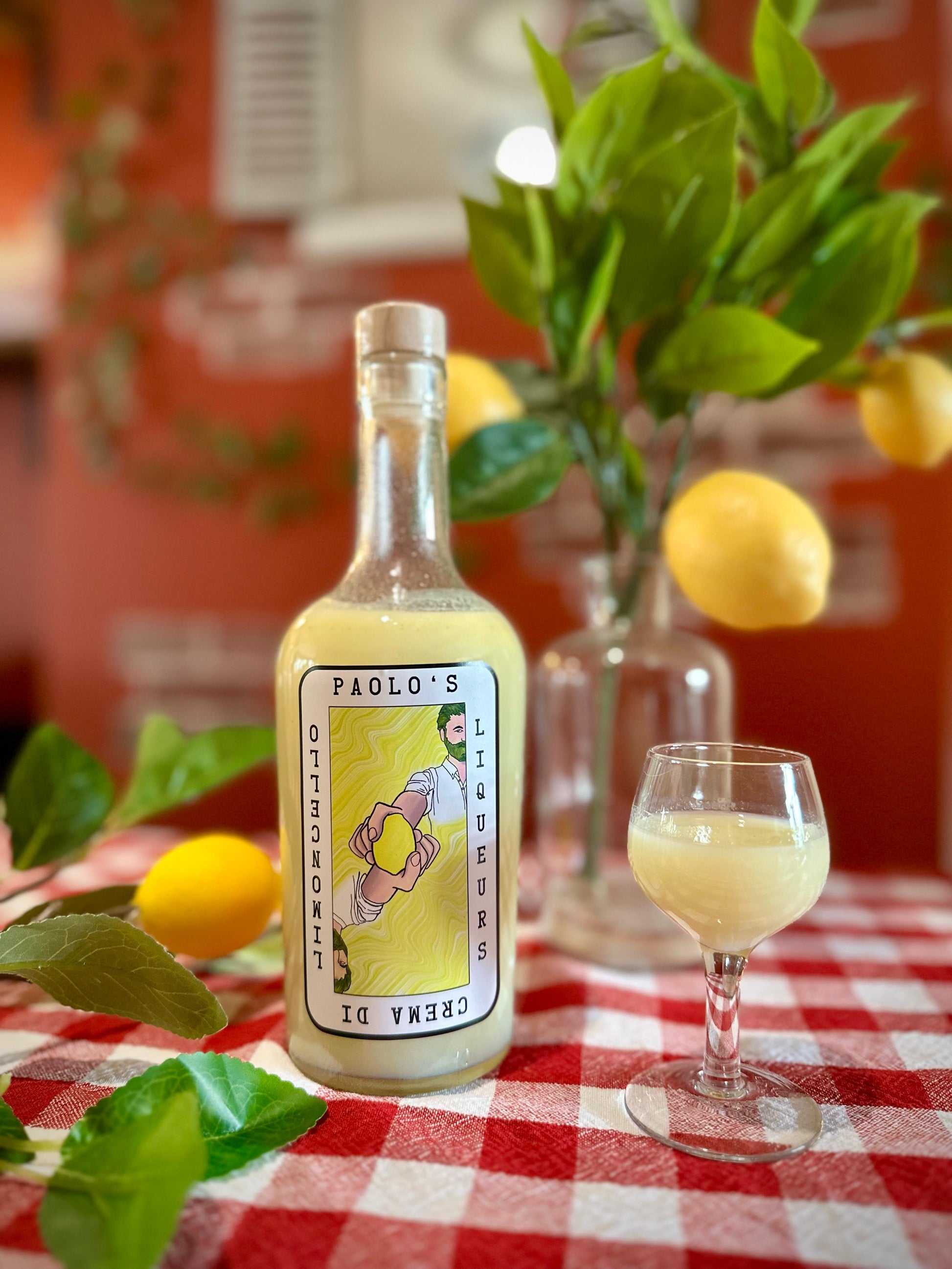 A picture of bottle of crema di limoncello on a chequered table cloth by Paolo's Liqueurs